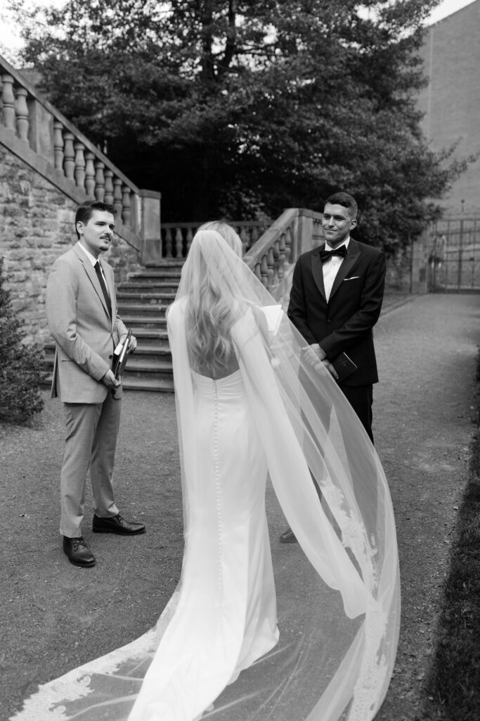 groom looks lovingly at the bride while she reads her vows to him 