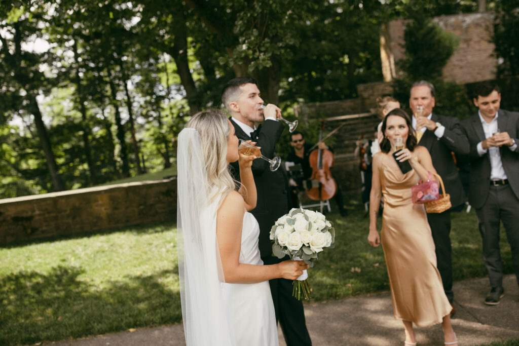 the bride and groom enjoy champagne following the sharing of vows in their wedding ceremony