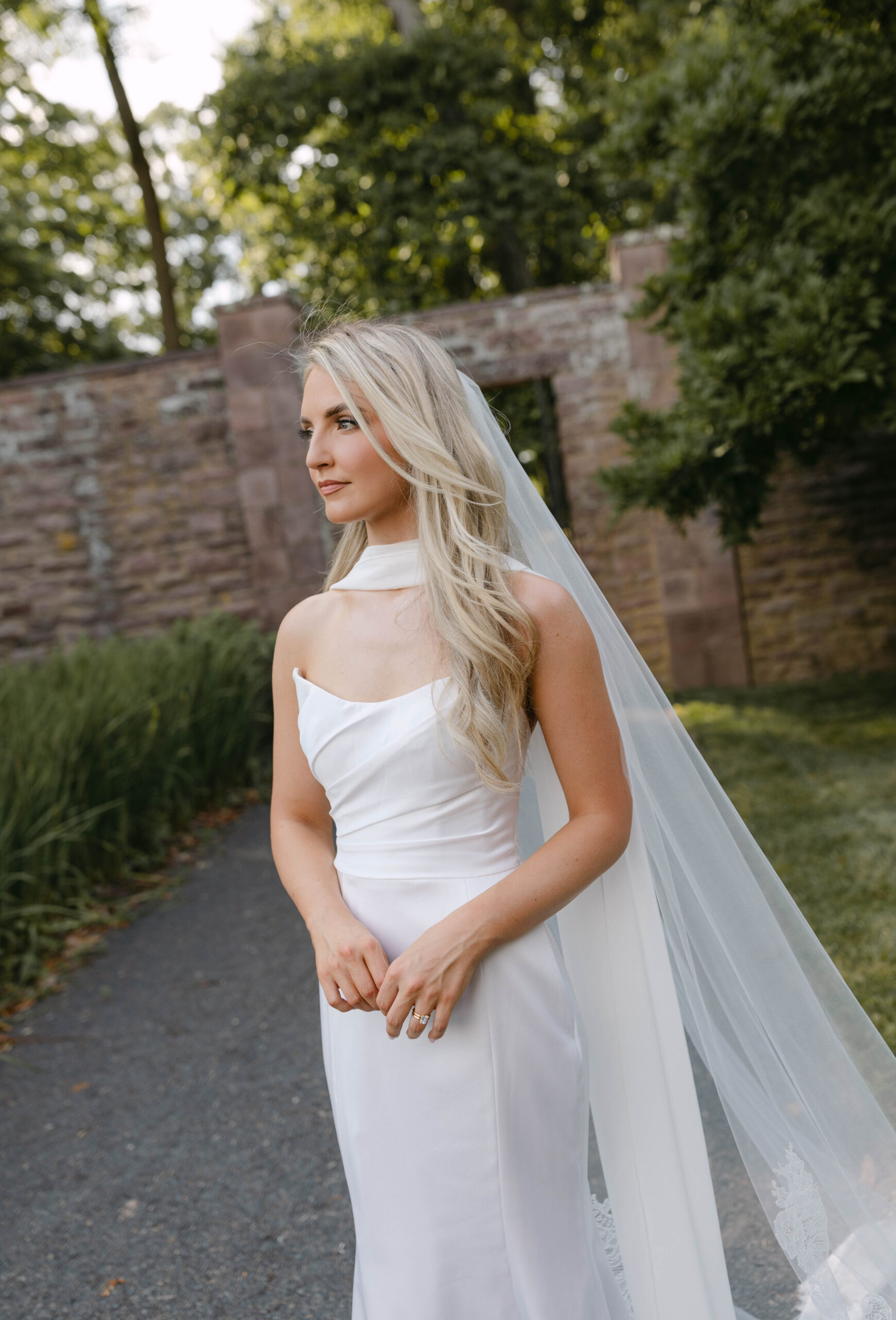 the bride and groom pose for portraits in a classic timeless white gown and black tuxedo in the lush gardens of Tyler Gardens