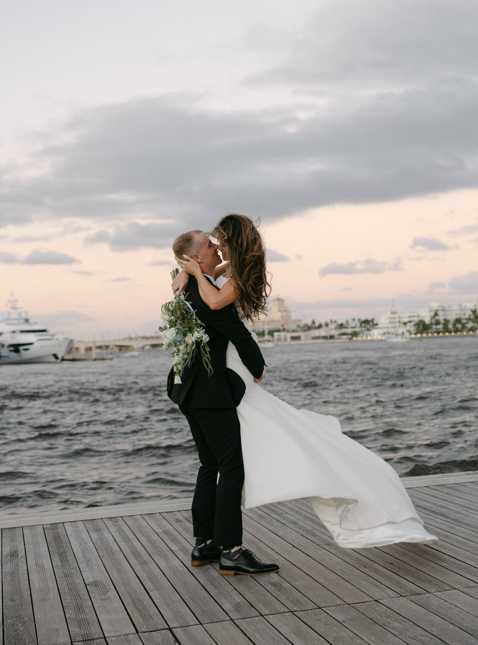 Couple poses for photo on their wedding day on a dock in Palm Beach, Florida